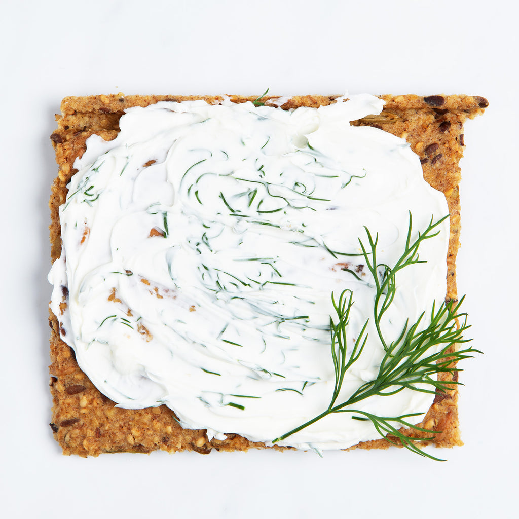 Chili and Coriander Knekkebrød served with cream cheese and dill on a white background